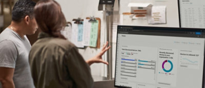 رجل يرتدي قميصاً رمادياً ينظر إلى شاشة كمبيوتر تعرض رسماً بيانياً.