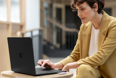A woman sitting at a table using a laptop.