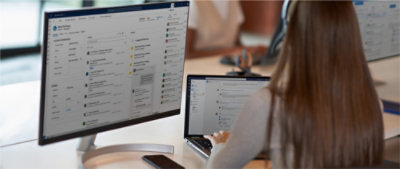 A woman with long hair typing on a laptop.