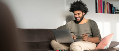 坐在沙發上使用膝上型電腦的男人。