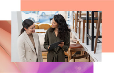 兩名穿著西裝的女性看著平板電腦。