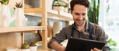 一個穿著圍裙的男人看著平板電腦。