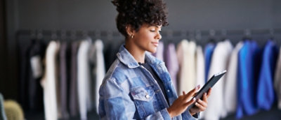 一位身穿牛仔夾克、手持平板電腦的女士。