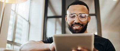 戴眼鏡並看著平板電腦的男人。