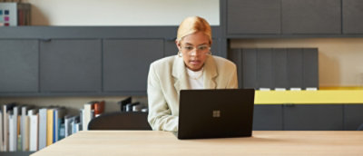 一名身穿白色上衣的女士正在使用膝上型電腦。