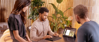 一位男士坐在桌前使用膝上型電腦。