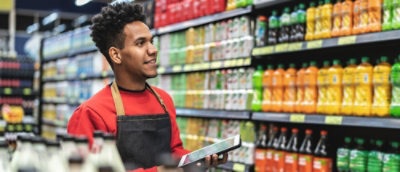 一名穿著紅色襯衫和黑色圍裙的男子手持平板電腦。