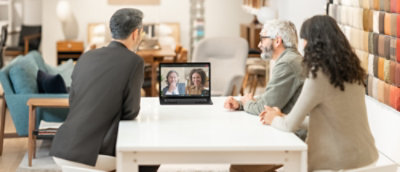 一群人圍坐在桌前，看著膝上型電腦螢幕。