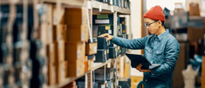 一名在倉庫中持平板電腦的男子。