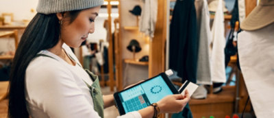 一名手持平板電腦和信用卡的女性。