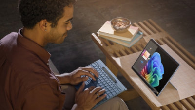 Een man die naar het scherm kijkt en iets van het toetsenbord typt