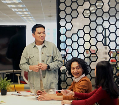 Een man die staat en praat met twee vrouwen die op de stoel zitten