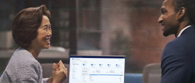 Twee personen die met elkaar praten terwijl ze naar het scherm kijken