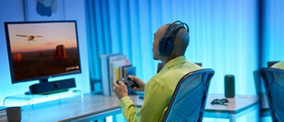 Een persoon die een hoofdtelefoon draagt en naar het bureaublad kijkt