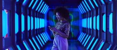 Een vrouw die haar telefoon in een blauwe lichtachtergrond gebruikt