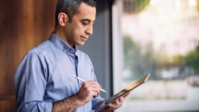 Un uomo con in mano tablet e stilo.