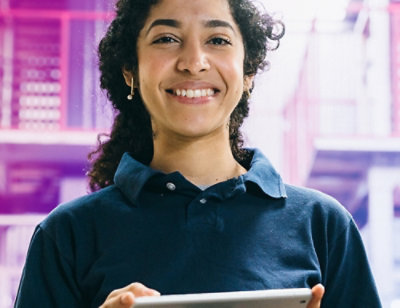 A woman smiling while holding a tablet.