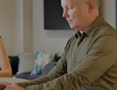 A man sitting at a table with his eyes closed.
