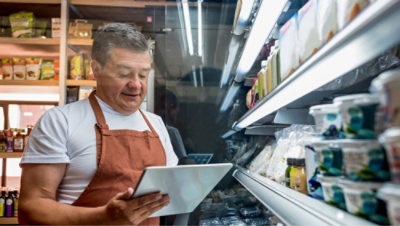 Людина у фартуху дивиться на планшет