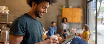 A man smiling while holding a cup of coffee.