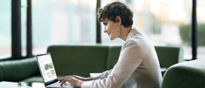 A woman sitting on a couch using a laptop.