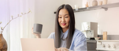  Женщина с длинными волосами сидит за столом с ноутбуком и чашкой.