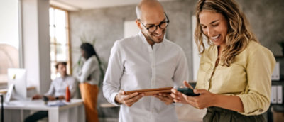 A man and woman looking at a tablet.
