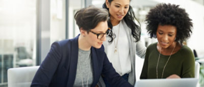 A group of women looking at a piece of paper.