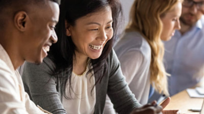 Dos personas sentadas frente a frente mirando la pantalla de un portátil.