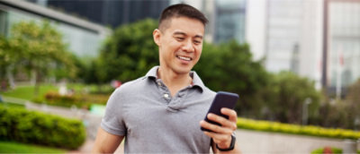 A person looking at a cellphone and smiling.
