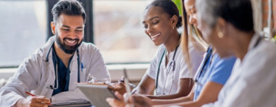 A group of people looking at a tablet.