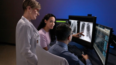 A group of people looking at a computer screen.