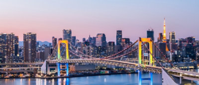 Eine Brücke über Wasser mit einer Stadt im Hintergrund.