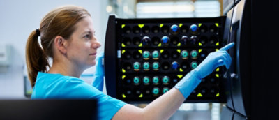 Eine Frau mit blauen Handschuhen, die ein blaues Objekt hält.