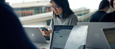 Eine Frau mit Brille, die nach unten schaut.