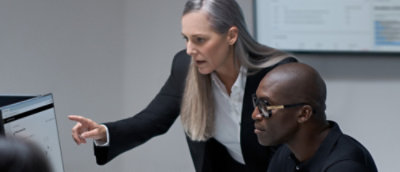 Eine Frau, die auf einen Mann zeigt, der eine Brille trägt.