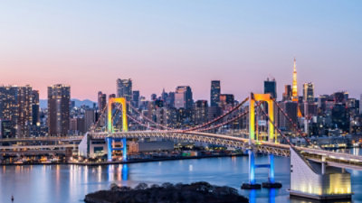 Eine Brücke über Wasser mit einer Stadt im Hintergrund.