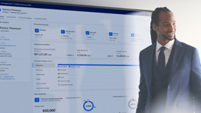 A man in a suit looking at a computer screen displaying numerical data.