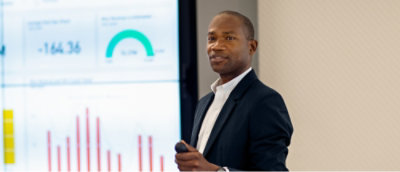 A person in a suit holding a microphone.