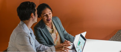 A man and woman looking at a laptop.
