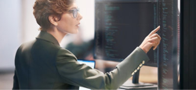 a person pointing to a large desktop monitor