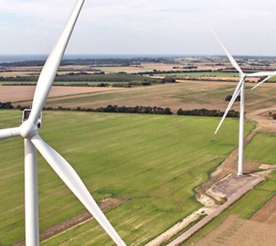 Des éoliennes dans un champ sous un ciel bleu avec des nuages.