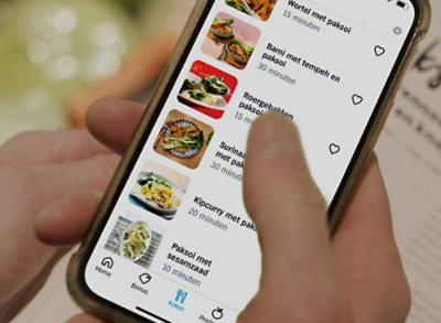 Une main tenant un téléphone affichant du texte sous forme de liste.