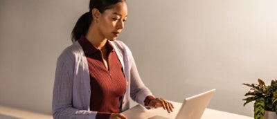  Une femme est assise à un bureau et regarde un ordinateur portable