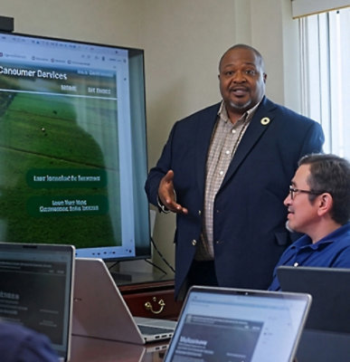 Person giving a presentation beside a screen in a meeting room