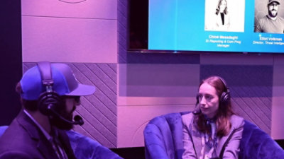A man and woman sitting in chairs wearing headphones.