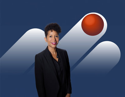 ผู้หญิงชาวอเมริกันเชื้อสายแอฟริกากำลังยิ้มอยู่เบื้องหน้าท้องฟ้าสีคราม