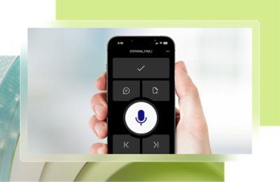 En hånd som holder en smarttelefon som viser et blått mikrofonikon i en hvit sirkel.