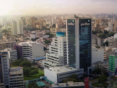 A high angle view of a city with tall buildings and white clouds in the blue sky.
