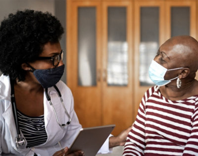 A doctor and patient wearing face masks.